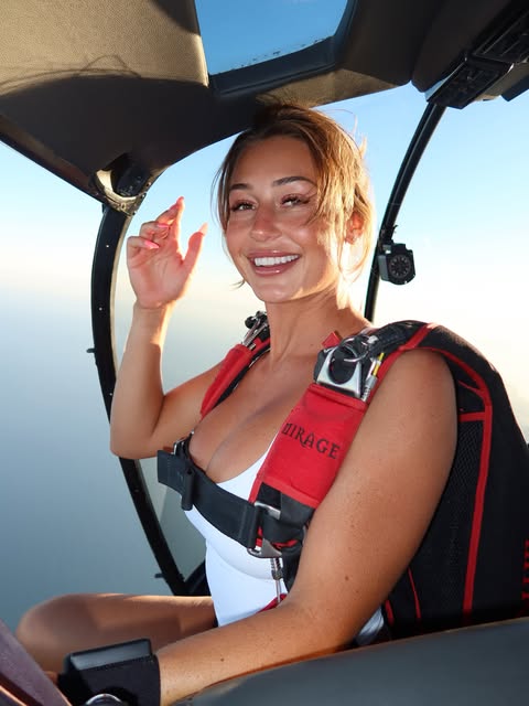 Cora smiling in an aircraft, wearing her skydiving harness